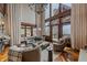 Spacious living room with high ceilings, stone fireplace, and sliding doors to the patio at 34650 Sleeping Fox Trl, Evergreen, CO 80439