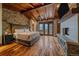 Spacious bedroom with wood ceiling, stone accent wall, fireplace, and a private balcony at 34650 Sleeping Fox Trl, Evergreen, CO 80439