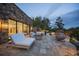 Inviting outdoor patio with comfortable seating, a fire pit, and views of the beautifully landscaped backyard at 34650 Sleeping Fox Trl, Evergreen, CO 80439