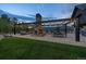 Beautiful outdoor stone patio featuring a fireplace and pergola with string lights, offering serene views of the surrounding landscape at 34650 Sleeping Fox Trl, Evergreen, CO 80439