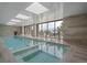 Inviting indoor pool area with comfortable lounging furniture and scenic views through expansive windows at 34650 Sleeping Fox Trl, Evergreen, CO 80439