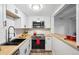 Updated kitchen featuring modern appliances, white cabinetry, and butcher block counters at 9700 E Iliff Ave # A3, Denver, CO 80231