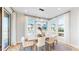 Sunlit dining area featuring a modern light fixture, large windows, and sleek white curtains at 5567 Moosehead Cir, Longmont, CO 80503