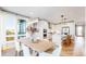 Dining area transitioning into a modern kitchen with stainless steel appliances and white cabinetry at 5567 Moosehead Cir, Longmont, CO 80503