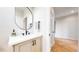 Contemporary powder room with sleek fixtures, oval mirror, and stylish herringbone flooring at 5567 Moosehead Cir, Longmont, CO 80503