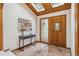 Sunlit entryway with skylights, wood ceiling, tile floor, and a wooden front door at 6723 Perry Park Blvd, Larkspur, CO 80118