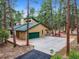 Exterior of a two-story home with a three-car garage surrounded by a forest of mature pine trees at 6723 Perry Park Blvd, Larkspur, CO 80118