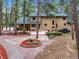 Lush exterior with mature evergreens, a two-story home with patio seating and intricate red rock landscaping details at 6723 Perry Park Blvd, Larkspur, CO 80118