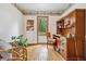 Bright home office boasts a built-in desk, wood floors, and a tranquil view to the outdoor area through a large window at 6723 Perry Park Blvd, Larkspur, CO 80118