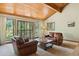 Cozy living room with wood paneled ceiling, large windows, and comfortable seating at 6723 Perry Park Blvd, Larkspur, CO 80118