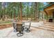 Outdoor dining space features a patio table and seating, stone pavers, and mature pines at 6723 Perry Park Blvd, Larkspur, CO 80118