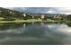 Picturesque community pond surrounded by lush greenery, mountains, and unique rock formations at 6723 Perry Park Blvd, Larkspur, CO 80118