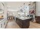 Spacious kitchen with granite counters, large island, and views into the dining and living area featuring stone fireplace at 52 Simmental Loop, Castle Rock, CO 80104