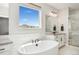 Bright main bathroom featuring a freestanding tub, marble counters, a glass-enclosed shower, and neighborhood views at 52 Simmental Loop, Castle Rock, CO 80104