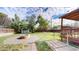 Expansive backyard with fire pit, grassy lawn, mature trees, deck, and storage shed at 821 Clarkson Ct, Denver, CO 80229
