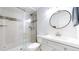 Modern bathroom with glass shower, round mirror, and stylish gray vanity at 821 Clarkson Ct, Denver, CO 80229