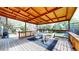 Outdoor covered patio with wood ceiling, table, chairs, and wood railing overlooking backyard at 821 Clarkson Ct, Denver, CO 80229