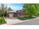 Charming two-story home features red brick, solar panels, attached garage, long driveway and a well-maintained front lawn at 821 Clarkson Ct, Denver, CO 80229