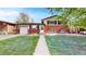 Charming home with brick facade, attached garage, manicured lawn, and walkway to front door at 821 Clarkson Ct, Denver, CO 80229