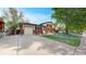 Charming two-story home with brick facade, attached garage, manicured lawn, and mature trees at 821 Clarkson Ct, Denver, CO 80229