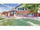 Home with brick facade, attached garage, manicured lawn, and walkway to front door at 821 Clarkson Ct, Denver, CO 80229