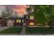Charming brick home with solar panels, a well-maintained lawn, and mature tree at sunset at 821 Clarkson Ct, Denver, CO 80229