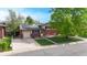Charming two-story home features red brick, solar panels, attached garage, long driveway and a well-maintained front lawn at 821 Clarkson Ct, Denver, CO 80229