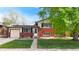 Charming two-story home features red brick, solar panels, attached garage, and a well-maintained front lawn at 821 Clarkson Ct, Denver, CO 80229