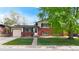 Charming two-story home features red brick, solar panels, attached garage, and a well-maintained front lawn at 821 Clarkson Ct, Denver, CO 80229