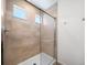 Modern tiled shower with glass enclosure and small windows for natural light at 1164 Sugarloaf Ln, Erie, CO 80516