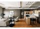 Spacious living area featuring hardwood floors, neutral tones, and a view of the kitchen with island seating at 1555 California St # 609, Denver, CO 80202