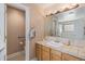Bathroom featuring a tiled vanity, decorative mirror, and a separate toilet room at 16029 W 75Th Pl, Arvada, CO 80007
