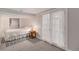 Cozy bedroom with soft lighting, neutral decor, and doors leading to another room at 16029 W 75Th Pl, Arvada, CO 80007