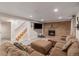 The basement living room features a brick fireplace, built-in shelving, and a flat screen TV at 16029 W 75Th Pl, Arvada, CO 80007