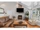 Bright and airy living room featuring a stone fireplace, vaulted ceilings, and lots of natural light at 16029 W 75Th Pl, Arvada, CO 80007