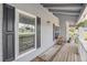 Covered wooden porch with decorative antique wagon wheels and views of the lawn at 16029 W 75Th Pl, Arvada, CO 80007