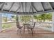 Covered porch with white railings features outdoor seating and views of the surrounding landscape at 16029 W 75Th Pl, Arvada, CO 80007
