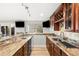 Well-appointed home bar featuring custom cabinetry, granite countertops, tile backsplash and two televisions at 23427 Song Bird Hills Pl, Parker, CO 80138