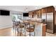 Basement bar with counter seating, wood cabinets, and exterior view window at 23427 Song Bird Hills Pl, Parker, CO 80138