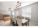 Bright dining room featuring a large table with seating for eight, modern lighting, and natural light from two windows at 23427 Song Bird Hills Pl, Parker, CO 80138
