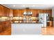 Gourmet kitchen featuring custom cabinets, stainless steel appliances, and center island with granite countertops at 23427 Song Bird Hills Pl, Parker, CO 80138