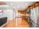 Open layout kitchen with stainless steel appliances, island, and hardwood floors leading to living space at 23427 Song Bird Hills Pl, Parker, CO 80138