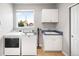 Laundry room featuring white appliances, a window with a neighborhood view, and built-in storage at 23427 Song Bird Hills Pl, Parker, CO 80138