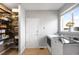 Bright laundry room with white appliances, a storage closet, and a window overlooking the neighborhood at 23427 Song Bird Hills Pl, Parker, CO 80138