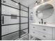 Stylish bathroom features a glass-enclosed shower, white vanity, and decorative tile flooring at 15310 E 108Th Way, Commerce City, CO 80022