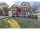 Attractive home with a well-maintained lawn, stone accents, and a welcoming porch at 15310 E 108Th Way, Commerce City, CO 80022