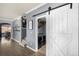 Well-lit laundry room featuring a sliding barn door and modern washer and dryer at 15310 E 108Th Way, Commerce City, CO 80022