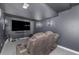 Home theater with reclining seating, large screen TV, sconce lighting, and dark gray walls at 15310 E 108Th Way, Commerce City, CO 80022