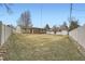 Large backyard with a lush lawn, mature trees, and a white privacy fence at 4534 W 65Th Ave, Arvada, CO 80003