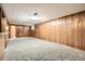 Spacious basement area with wood paneling, carpet, bar, and access to other rooms at 4534 W 65Th Ave, Arvada, CO 80003